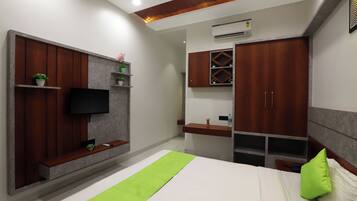 Un dormitorio moderno con cama, televisor montado en un panel de madera, armario y una pequeña estantería con plantas.