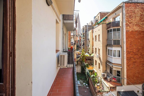 A narrow urban alleyway between buildings with balconies, air conditioning units, and some greenery. - 21CRM1068 - Fantastic & tipical Catalonian flat (Barcelona)