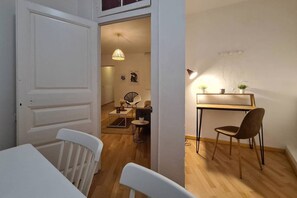 A compact living space with a dining area, a small kitchen, and a workspace. - 21ara1085- 4br apartment in Gótico (Barcelona)