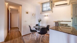 A compact kitchen with a dining area, a small window, and a built-in sink. - 32ara1086 - 3 bedrooms apartment (Barcelona)
