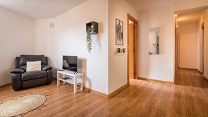 A modern living room with a leather sofa, a small white table, and a decorative plant. - 32ara1086 - 3 bedrooms apartment (Barcelona)