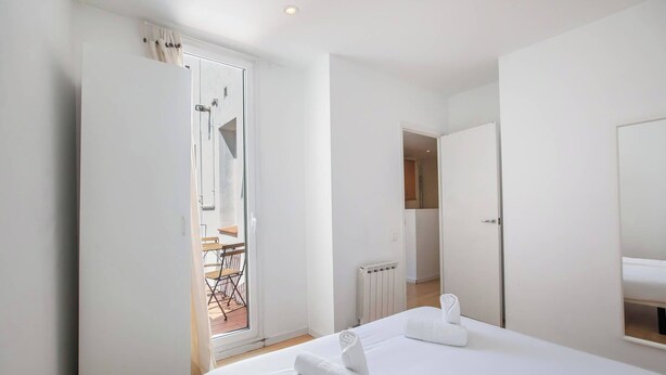 Ein Hotelzimmer mit Bett, Bad und Blick auf den Balkon.