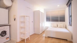 A compact bedroom with a bed, a washing machine, and a wardrobe. - BPAR1088 - Cozy flat near the beach (Barcelona)