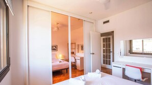 Ein Schlafzimmer mit einem Bett, einem Schreibtisch, einem Stuhl und einem Kleiderschrank.