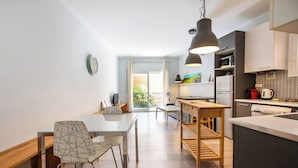 A modern kitchen with a dining area, wooden furniture, and a view to the outside.