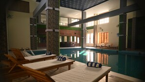 Un área de piscina con sillas de descanso y un bar.