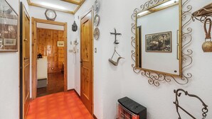 Ein Flur mit Holztüren, einem roten Teppich und einem Spiegel mit dekorativem Rahmen.