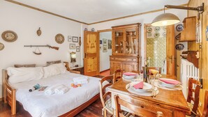 Ein Zimmer mit einem Bett, einem Holztisch, Stühlen und einem Schrank.