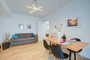 Un salon moderne avec un canapé, une table à manger et des chaises.