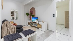 A modern living room with a sofa, a TV, a coffee table, and a small side table.