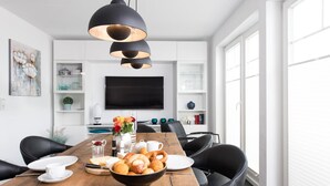 A modern dining area with a wooden table, black chairs, and a black pendant light. - Cozy home in Olpenitz with sauna (Olpenitz)