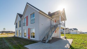 A modern two-story house with a balcony and a staircase leading to the upper floor. - Nice apartment in Olpenitz with sauna (Olpenitz)