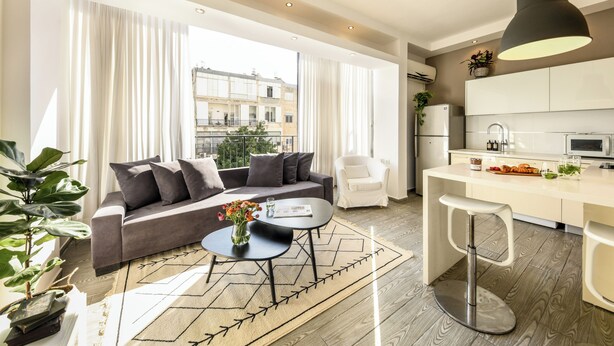 Un salon moderne avec un canapé, une table basse et une vue sur la ville.