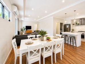 Un apartamento moderno con comedor, cocina, sala de estar y televisor.