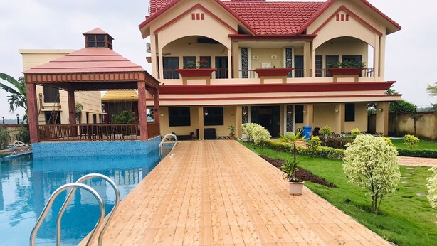 A large house with a swimming pool, a wooden deck, and a well-maintained garden. - GHARANA RESORT (Chandannagar)
