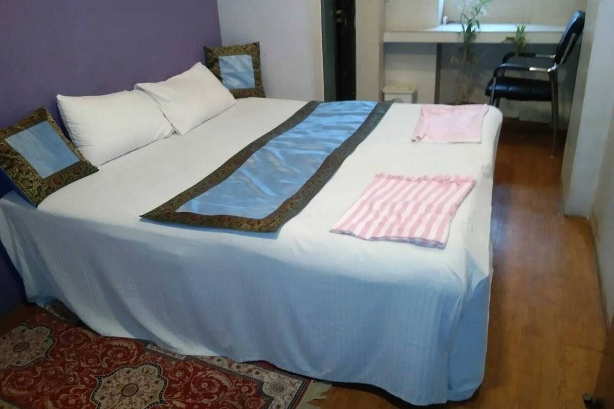 Un dormitorio con una cama grande, un escritorio y una silla.