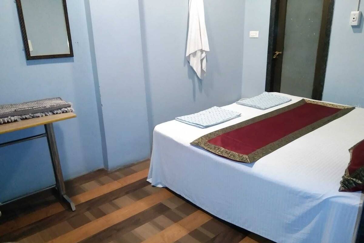 Una habitación con una cama, un escritorio pequeño y una silla.