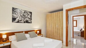A hotel room with a large bed, wooden wardrobe, and a painting of a tiger. - Finca in Mallorca with Private Pool & Views (Son Macià)