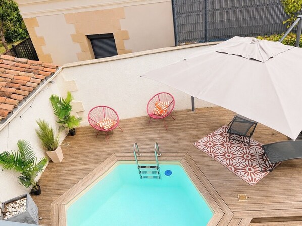 A rooftop pool area with a diving board, two pink chairs, and a large umbrella. - NEW Duplex Hyper Centre Avec Piscine (Bergerac)
