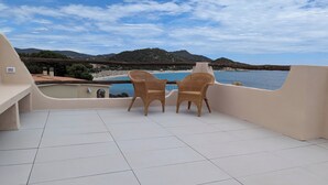 A balcony with two wicker chairs facing a beach and mountains. - Villa a few steps from the sea of Villasimius (Villasimius)