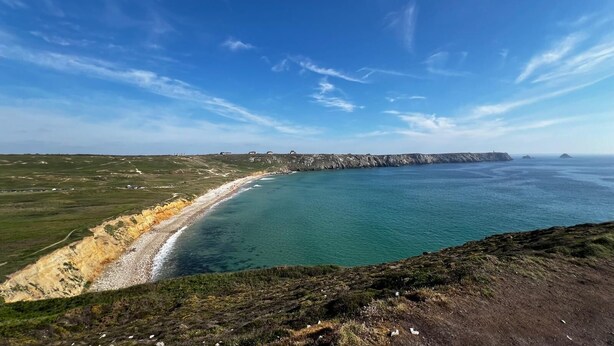 Un paisaje costero con vista despejada al mar y un acantilado distante.