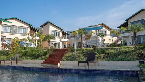 Zona residencial con piscina, varias casas con balcones y una escalera que conduce a un nivel superior.