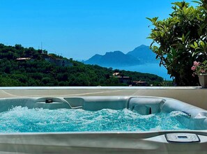 A hot tub with a view of a mountainous landscape and a body of water. - Villa Luci di Capri, Sorrento Coast - New Jacuzzi® Spa, Solar Shower & Lift (Massa Lubrense)