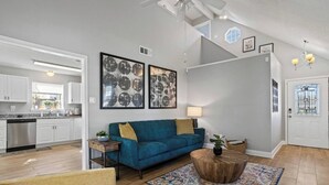Un salon moderne avec un canapé de couleur turquoise, une table basse en bois et un tapis à motifs.