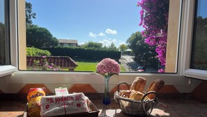 A kitchen counter with a basket of bread, a bottle of juice, and a package of coffee. - Casa Montañesa al Lado de la Playa (Somo)