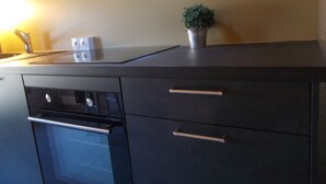 A kitchen with a stove, oven, and two drawers. - Tramontane, bedroom, and TV room. Near Avignon. (Jonquerettes)