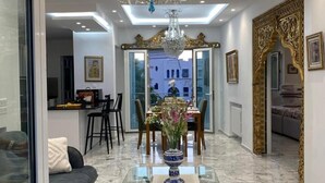 A modern interior with a glass coffee table, a chandelier, and a dining area. - Luxurious Sea View With Private Beach in Gammarth Marsa (La Marsa)