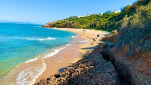 A coastal beach with rocky terrain, clear blue water, and a few people walking. - Luxurious Sea View With Private Beach in Gammarth Marsa (La Marsa)