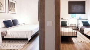 Un dormitorio con dos camas, piso de madera y ventana con vistas.
