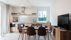 Una cocina moderna con comedor, televisor y ventana con vistas.