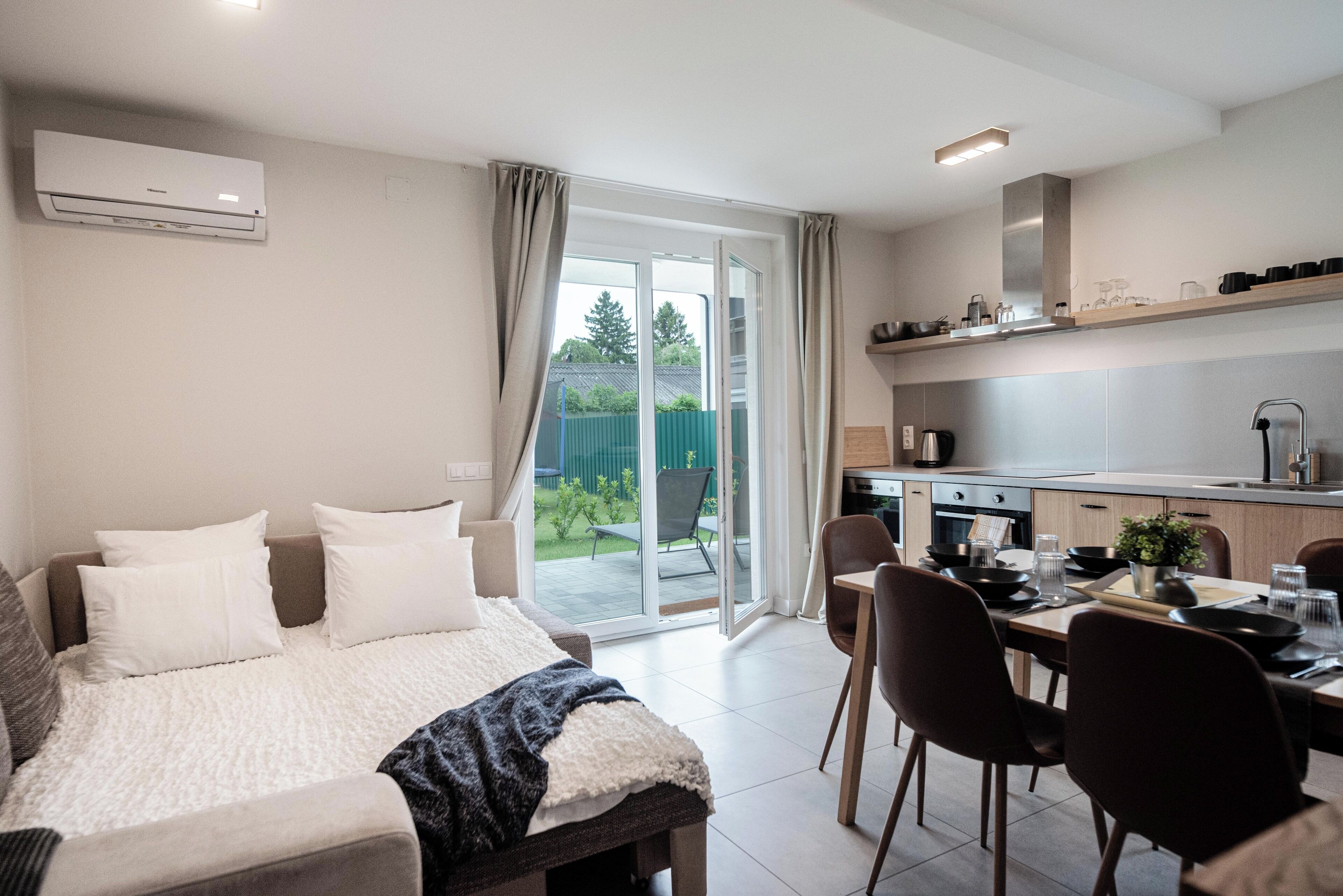Un dormitorio moderno con una cama grande, un comedor y una cocina.