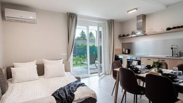 Un dormitorio moderno con una cama grande, un comedor y una cocina.