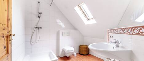 Un baño con ducha, inodoro y lavabo.