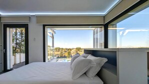 A modern bedroom with a large bed, a view of a cityscape, and a balcony. - Alternative Relax Rooms by Oikia Vacanze (Scorrano)