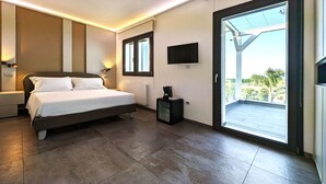 A modern bedroom with a large bed, a flat-screen TV, and a sliding glass door leading to a balcony. - Alternative Relax Rooms by Oikia Vacanze (Scorrano)