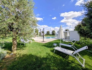 A poolside area with white lounge chairs, a small pool, and a tree. - Alternative Relax Rooms by Oikia Vacanze (Scorrano)
