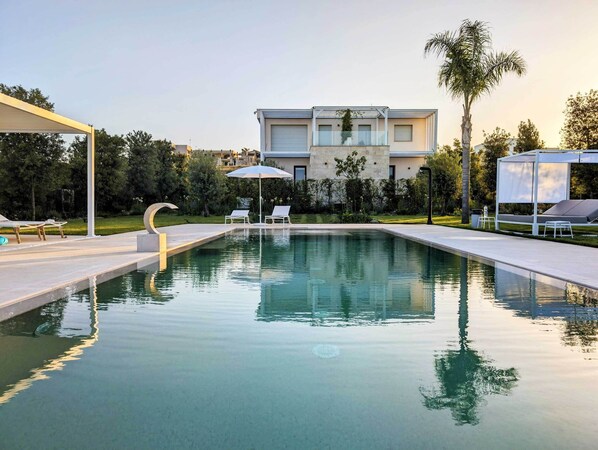 Una piscina al aire libre, cabañas de piscina gratuitas, sombrillas