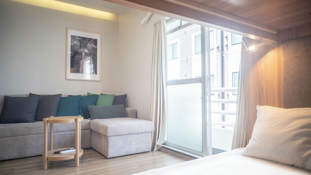 Een moderne hotelkamer met een bank, een voetenbankje en een bed.