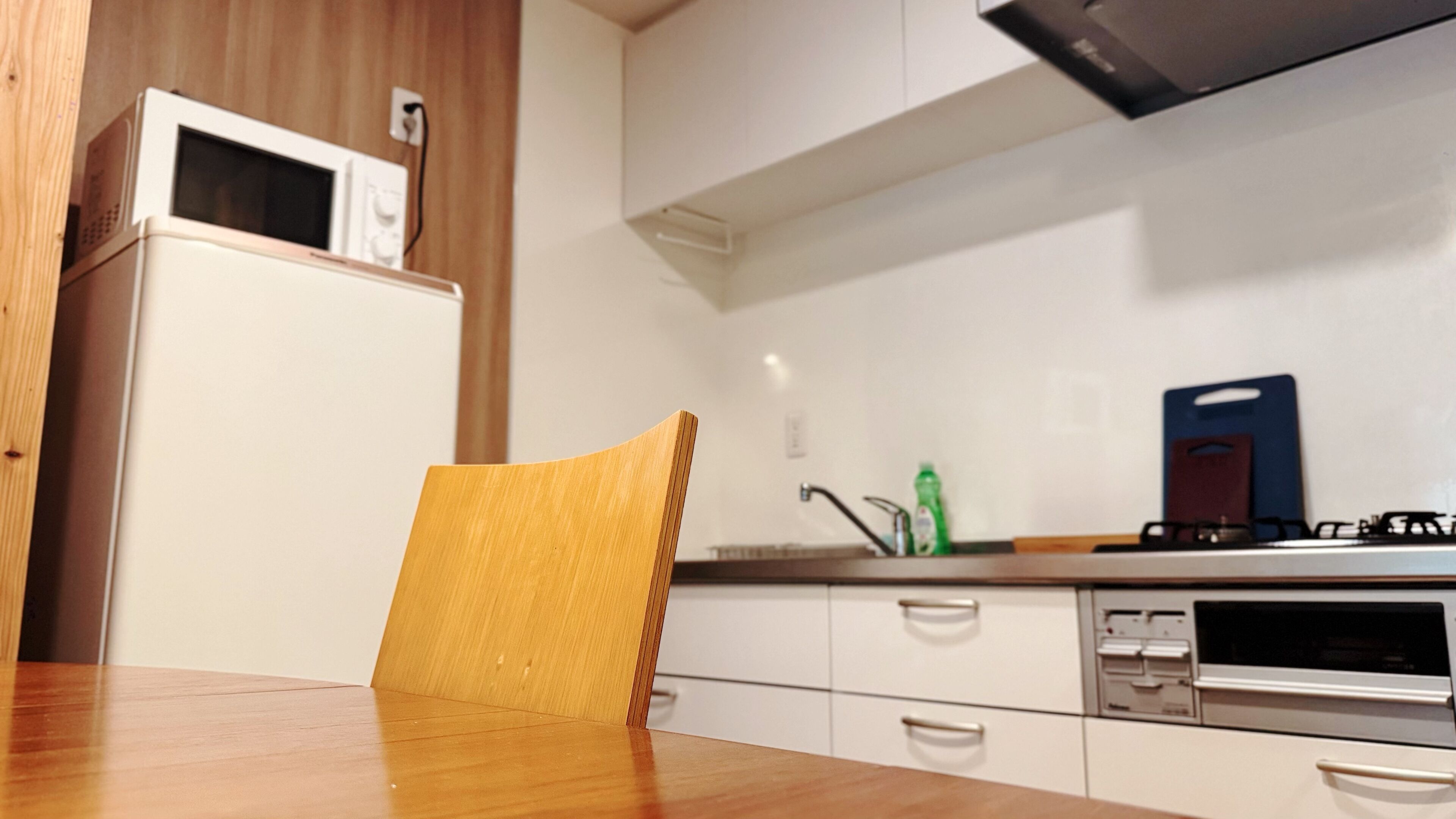 A kitchen with a microwave, stove, sink, and cabinets.