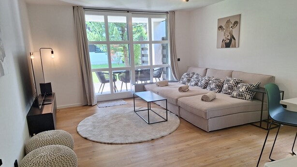 Una sala de estar moderna con sofá, una mesa de centro y un comedor.