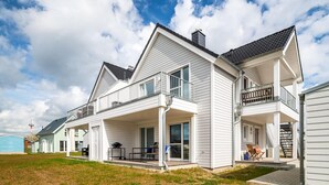 A two-story house with a balcony, a covered porch, and a chimney. - Pet friendly apartment in Olpenitz (Olpenitz)