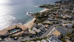 Un quartier résidentiel situé sur la côte, avec des maisons, une plage et une piscine.