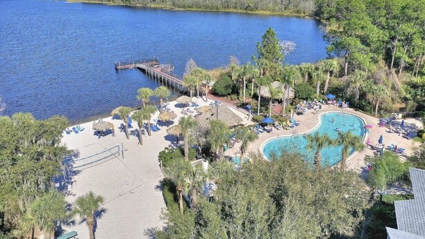 A resort with a swimming pool, beach area, and a pier extending into a lake. - Bahama Bay Resort * Disney Area * Free Parking (Davenport)
