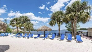 A beach with blue lounge chairs and palm trees. - Bahama Bay Resort * Disney Area * Free Parking (Davenport)