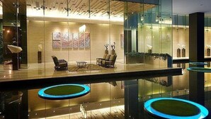 A modern lobby with glass walls, a reception desk, seating area, and decorative lighting. - M city ampang KL by Rit (Kuala Lumpur)