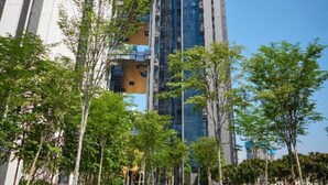 A modern high-rise building with a glass facade, surrounded by a well-maintained lawn and trees. - M city ampang KL by Rit (Kuala Lumpur)